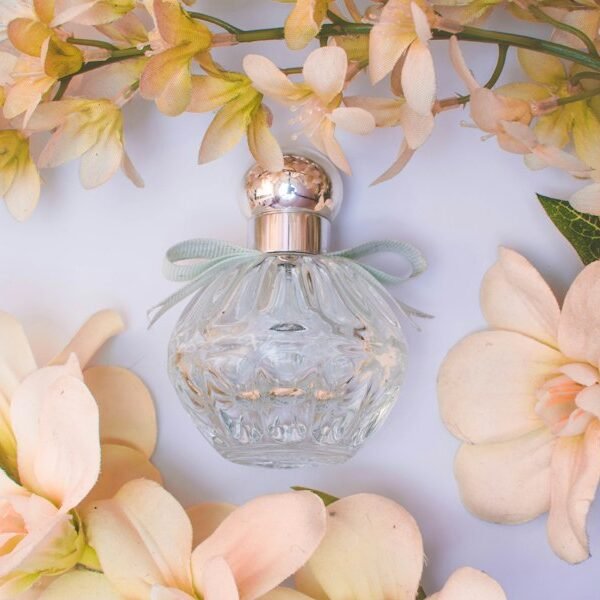 زجاجة عطر كلاسيكية بين الزهور
